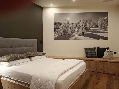 a bedroom with a bed and a painting on the wall at Casa Lucia in Valdidentro