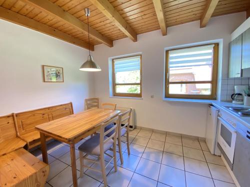 eine Küche und ein Esszimmer mit einem Holztisch und Stühlen in der Unterkunft Natur Ferienpark 27 - Ferienhaus Typ A in Nieheim