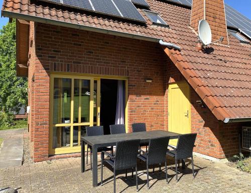 einen schwarzen Tisch und Stühle vor einem Backsteinhaus in der Unterkunft Natur Ferienpark 26 - Typ A in Nieheim