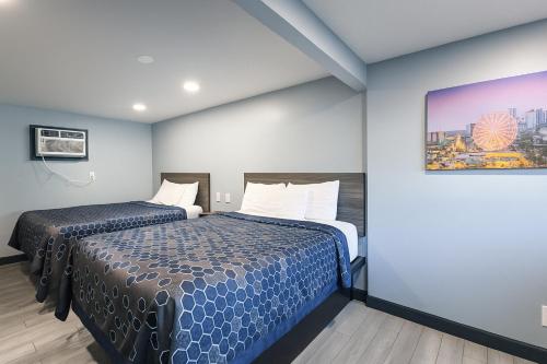 a hotel room with two beds and a painting on the wall at Hillsboro Inn & Suites in Hillsboro