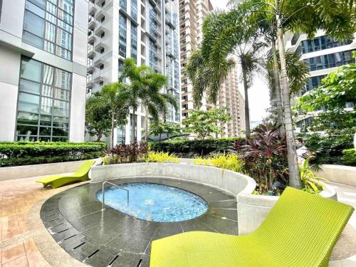 une terrasse avec un jacuzzi, des chaises jaunes et des arbres dans l'établissement The Viceroy Tower Staycation at McKinley Hills Taguig, à Manille
