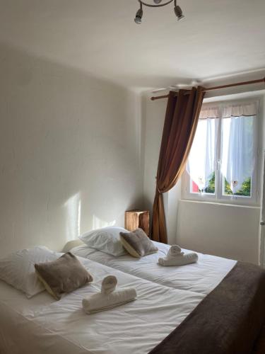 a bed with two towels on it with a window at Auberge Les Bastides 