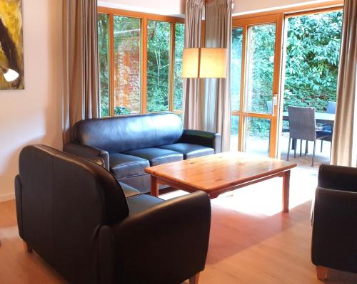 a living room with a couch and a table and chairs at Natur Ferienpark 8 - Typ A in Nieheim