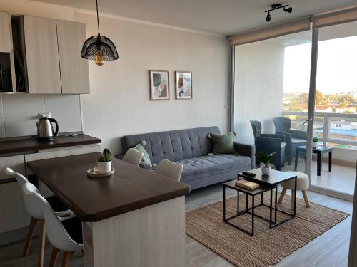 a kitchen and living room with a couch and a table at Departamento nuevo a 5 min de la playa 2D 2B in La Serena