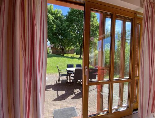 une vue d'un patio depuis une porte coulissante en verre dans l'établissement Natur Ferienpark 28 - Ferienhaus Typ A, à Nieheim