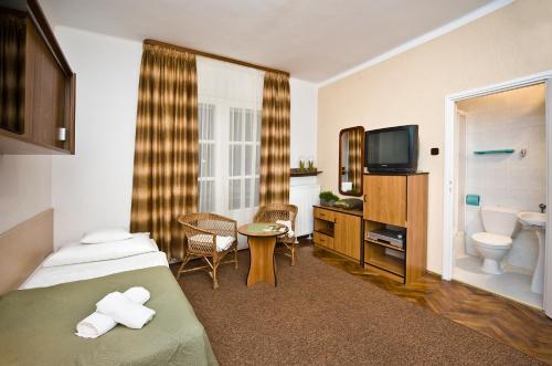 a hotel room with a bed and a bathroom at Dom Wypoczynkowy Helunia in Jurata