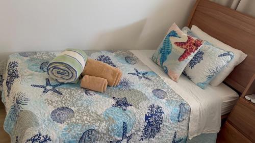 a bed with a quilt and pillows on it at Paradise Apt in Punta Cana in Punta Cana