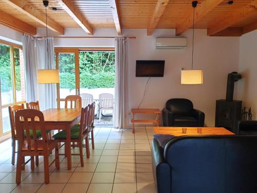 a living room with a dining room table and chairs at Haus 9 Natur Ferienpark, WLAN, Kostenfreier Parkplatz, Grillen auf der Terrasse Schöne Familienzeit! in Nieheim