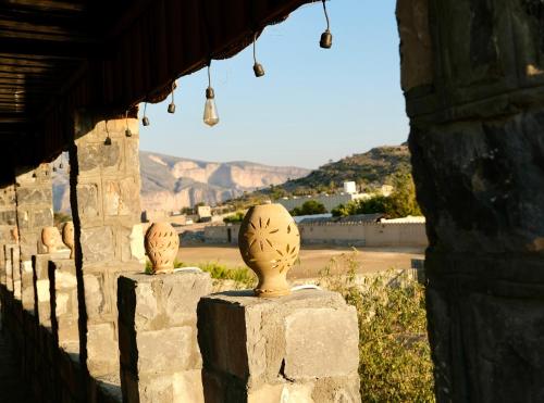 a group of stone vases sitting on a wall at Al Hudu Mountain House - Jebel Shams in Al Ḩayl