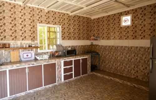 a kitchen with a counter in a room with wallpaper at Al Hudu Mountain House - Jebel Shams in Al Ḩayl
