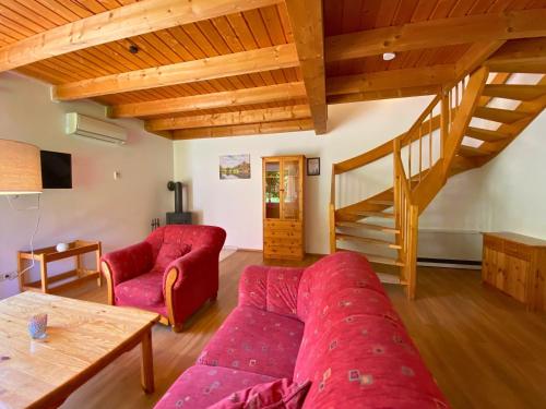a living room with a red couch and a staircase at Natur Ferienpark 25 - Typ A in Nieheim