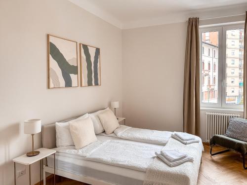 Una habitación blanca con una cama y una ventana. en Radiant Apartment near Milano, en Sesto San Giovanni