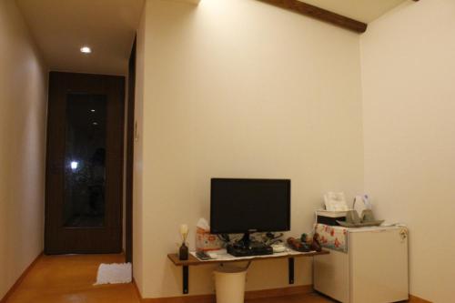 a living room with a television and a refrigerator at Sungsim Hanok Guesthouse in Jeonju