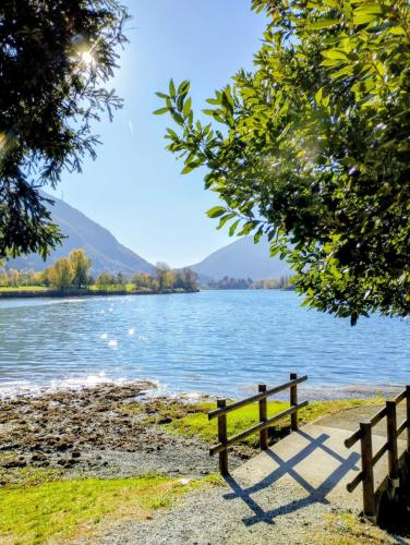 a bench sitting on the shore of a lake at Borgo Antico Lake Endine Hospitality in Endine Gaiano