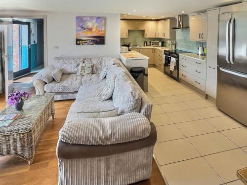 a living room with two couches and a kitchen at Barn Owl Cottage - Uk48510 in Kirk Hammerton