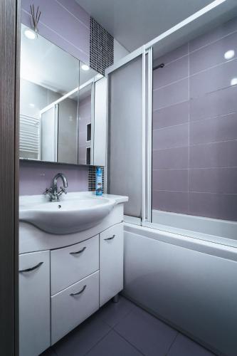 ein Badezimmer mit Waschbecken, Badewanne und Spiegel in der Unterkunft Testimiteanu Two in Chişinău