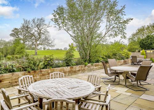a patio with a table and chairs and a fence at Ladera Retreat Lodges in Eaton