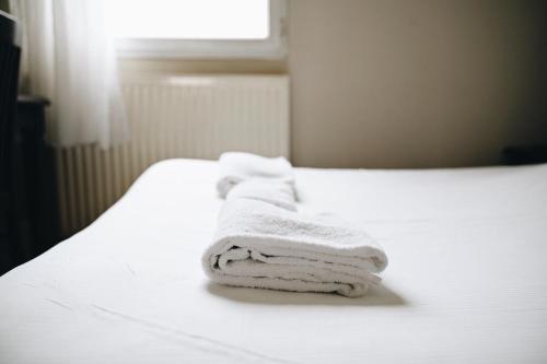 LimasにあるLogis Hôtel Novaの窓付きのベッドにタオルを積み重ねます。