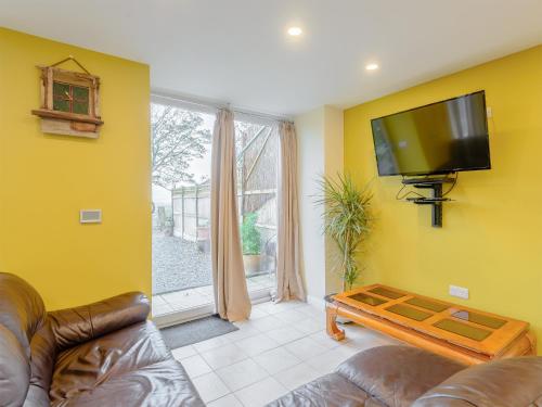 a living room with a couch and a flat screen tv at Dutch Barn Two - Uk12873 in Brynkir