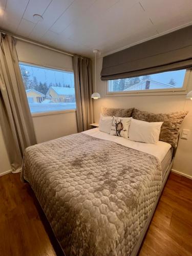 a bedroom with a large bed with a large window at Arctic Circle Guesthouse in Rovaniemi