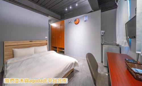 Un dormitorio con una cama, una mesa y un escritorio. en 新橙居-我們未與阿狗打訂房平台合作請勿在阿狗打訂房平台訂房, en Dalin