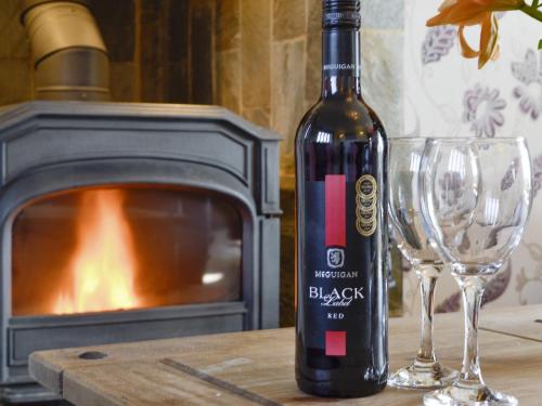 a bottle of black wine next to two wine glasses at Upper Close - Uk10873 in Evenjobb