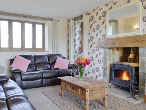 a living room with a leather couch and a fireplace at Upper Close - Uk10873 in Evenjobb