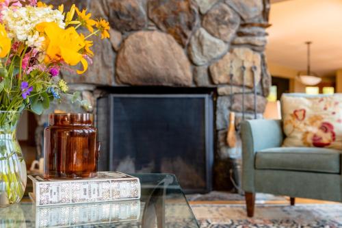 un salon avec une cheminée et un vase de fleurs dans l'établissement Valley View, à Stowe