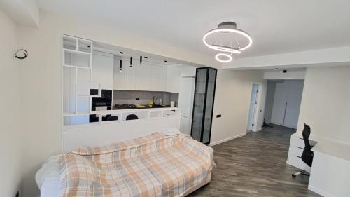 a white bedroom with a bed and a kitchen at Vila in Chişinău