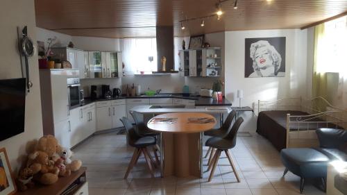 a kitchen and living room with a table and chairs at FERIENHAUS FISCHER in Zweibrücken