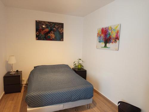 une chambre avec un lit et deux tableaux au mur dans l'établissement Escale a Brest, à Brest