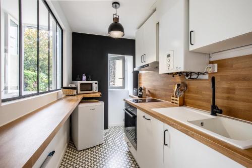 eine Küche mit weißen Schränken und einer Spüle in der Unterkunft L'Authentique - Centre ville de Dax avec jardin in Dax