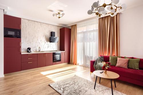 ein Wohnzimmer mit einem roten Sofa und einem Tisch in der Unterkunft Sika Opulent Grand Apartment in Arad