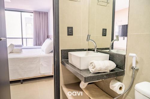 Un baño con lavabo y cama. en Emunah di Citta por Quarto à Vista, en Ilha da Restinga