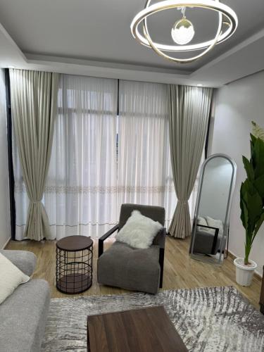 a living room with a chair and a chandelier at Book n Breeze in Nairobi