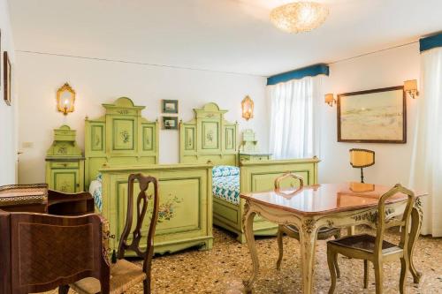 a bedroom with green furniture and a table and a bed at Ca' Magno by Venicevillas, dimora storica in Venice
