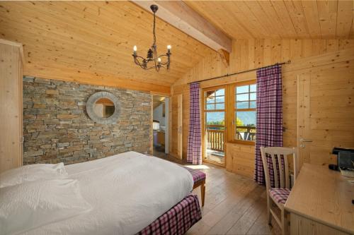 a bedroom with a bed and a stone wall at Between Boutique Hotel in Chamoson