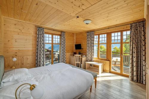 a bedroom with a large bed and a balcony at Between Boutique Hotel in Chamoson