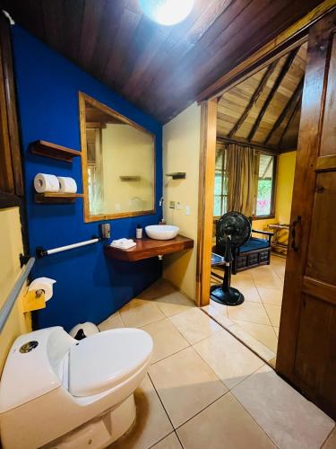 a bathroom with a toilet and a mirror at Huasquila Amazon Lodge in Cotundo