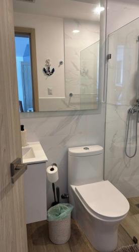 a white bathroom with a toilet and a shower at Paradise Apt in Punta Cana in Punta Cana