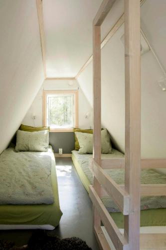 a room with two bunk beds in a attic at Small Cabin With Outdoor Kitchen By Forest Stream in Trollhättan