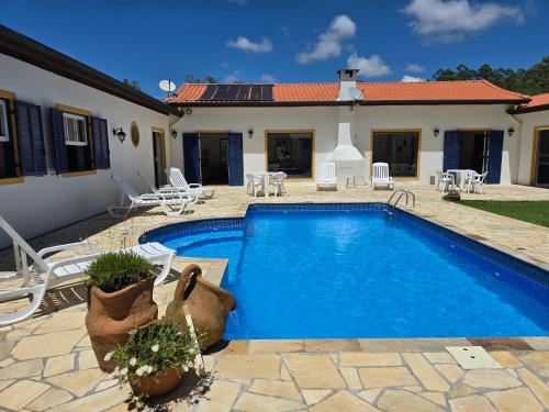 a swimming pool in front of a house at Pousada Quintal das Hortênsias in Salesópolis