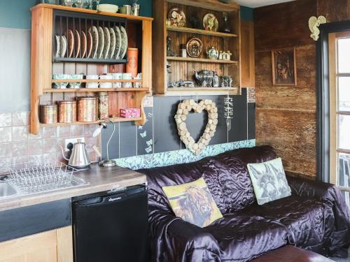 een woonkamer met een bank in een keuken bij The Peacock Roost - Uk46297 in Brynkir
