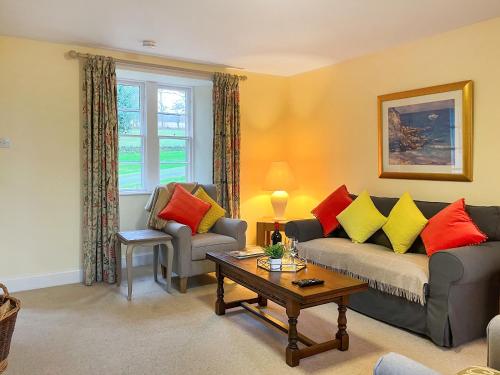 een woonkamer met een bank en een tafel bij Baldowrie Lodge in Ardler