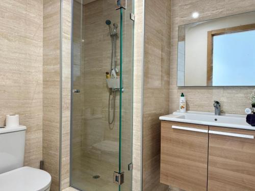 a bathroom with a shower and a toilet and a sink at Sea View Apartment & Swimming Pool in Sidi Bouqnadel