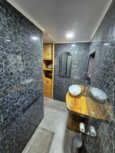 a bathroom with two sinks and a large shower at Casa de árbol Quillón in Quillón
