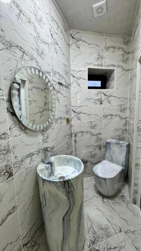 Un baño con bañera, lavabo y espejo. en Amour Homes 2, en Quba