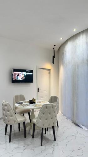 una sala da pranzo con tavolo, sedie e TV di Amour Homes 2 a Quba
