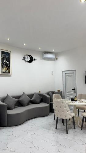 a living room with a couch and a table at Amour Homes in Quba