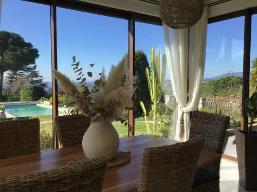 eine Vase aus Blumen auf einem Holztisch mit Stühlen in der Unterkunft Provencal Villa With Pool And Panoramic Views in La Gaude